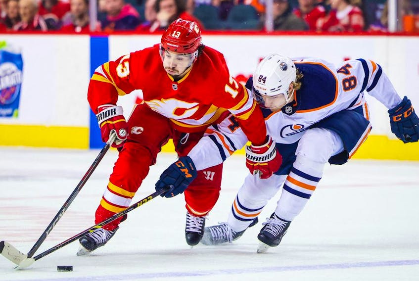 Edmonton Oilers defenceman William Lagesson checks Flames forward Johnny Gaudreau during game in Calgary on March 7, 2022. 