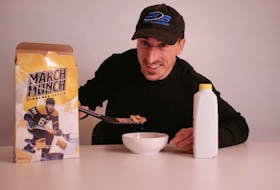 Boston Bruins winger Brad Marchand uses a mini hockey stick to take a scoop of his new cereal, March Munch.