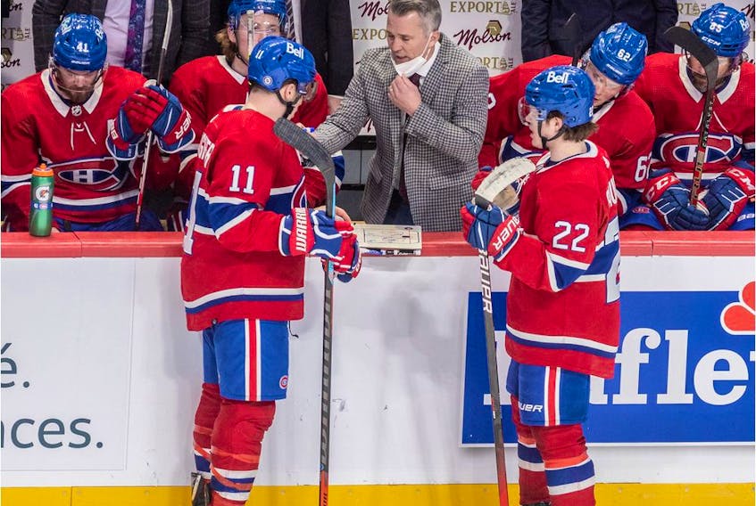 Montreal Canadiens head coach Martin St. Louis strategizes with wingers Brendan Gallagher, left, and Cole Caufield during third period of game against the Arizona Coyotes at the Bell Centre in Montreal on March 15, 2022.