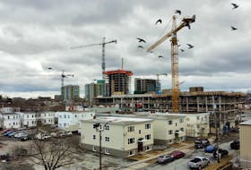 Cranes dwarf an old series of apartment buildings on Macara Street in March 2022.

Photo by Tim Krochak