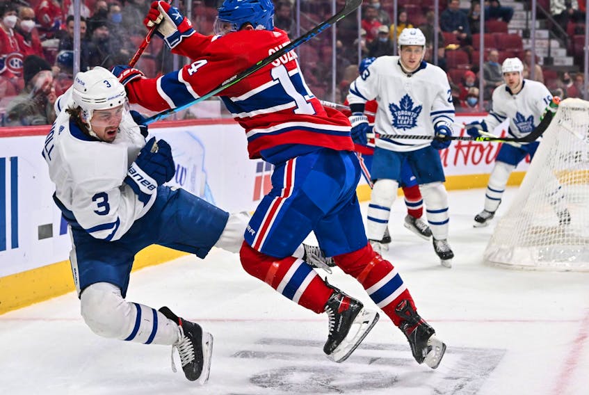Nick Suzuki of the Montreal Canadiens delivers a hit on Justin Holl of the Toronto Maple Leafs during the second period at the Bell Centre on Feb. 21, 2022 in Montreal.