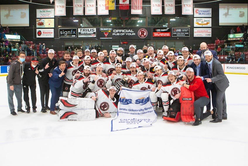 The UNB Reds celebrate their fourth consecutive Atlantic university men's hockey championship and 18th in program history. The Reds defeated the St. Francis Xavier X-Men 3-1 in Friday's one-game conference final in Fredericton. - James West / UNB Athletics