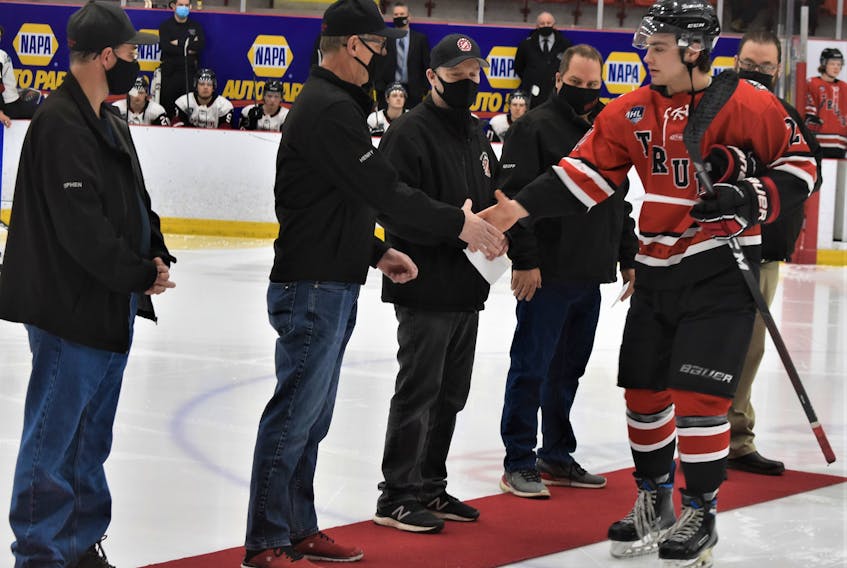 Local player Riley MacInnis makes a presentation to Henry Vissers of the Bible Hill Kinsmen, which will benefit the Multiple Sclerosis Society – Atlantic Division.