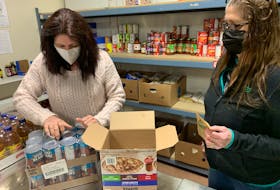 Colchester Food Bank executive director Darlene De Adder (left) unpacks food with volunteer Vi Blenkhorn at the organization’s Prince Street headquarters. Darrell Cole