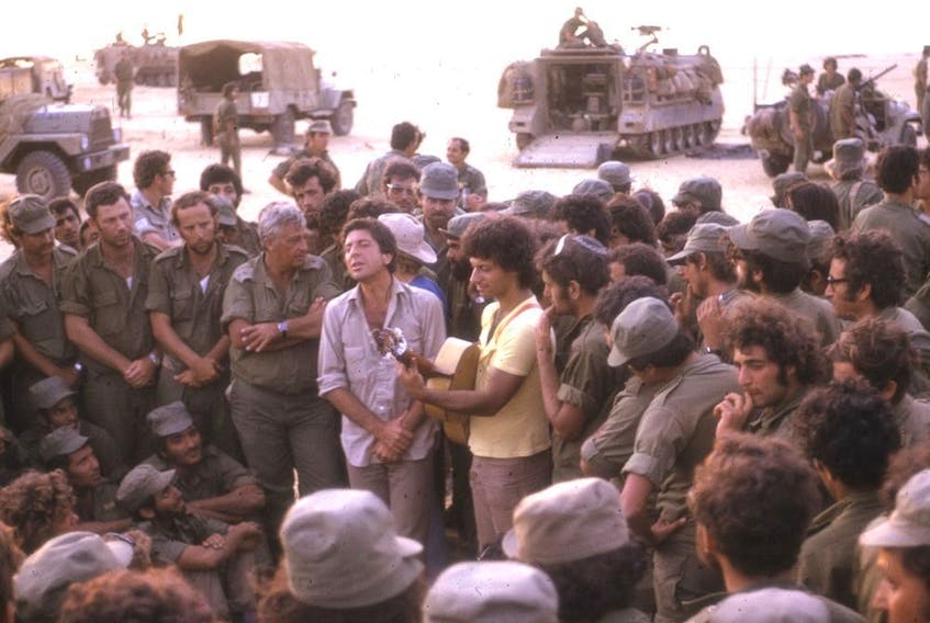 Leonard Cohen performs for Israeli troops in Sinai in October 1973, flanked by future prime minister Ariel Sharon, left, and Israeli musician Matti Caspi.