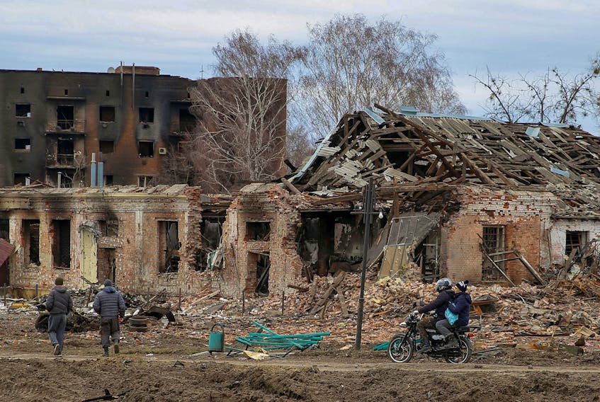 Local residents pass by buildings damaged by shelling as Russia’s attack on Ukraine continues in the town of Trostianets, in Sumy region, Monday, March 28, 2022. - Oleg Pereverzev / Reuters