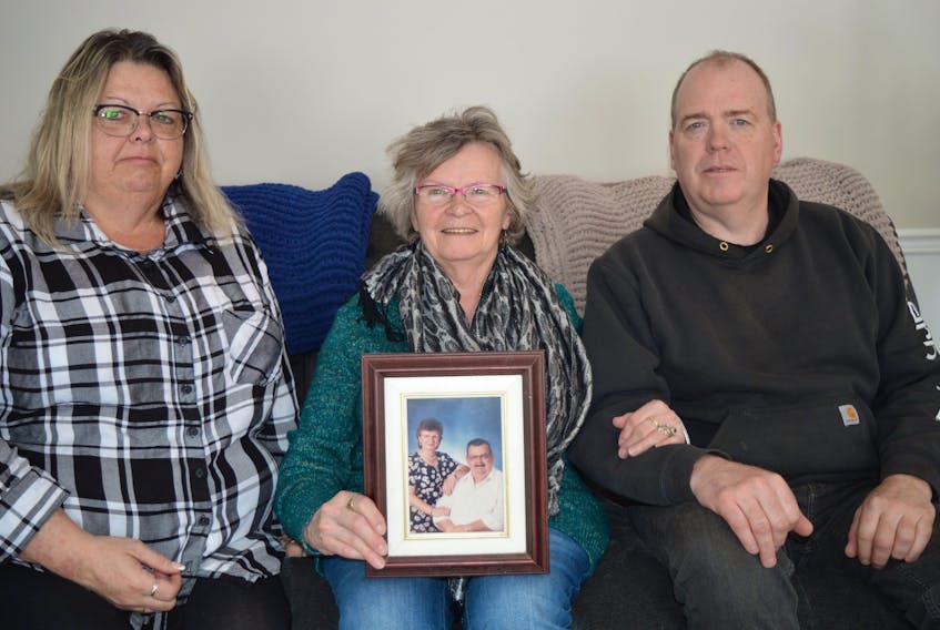Rita Corrigan, centre, holds a picture of her and her husband, Joe, who died on March 22. Joe drove for and owned City Taxi for nearly 50 years. Also pictured are her children, Helen, left, and Joey.