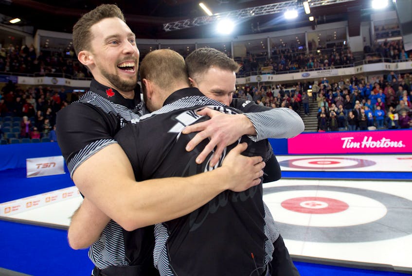 Charlottetown’s Brett Gallant, left, celebrates with teammates Geoff Walker, centre, and skip Brad Gushue after winning the Tim Hortons Brier on March 13 in Lethbridge, Alta. 
