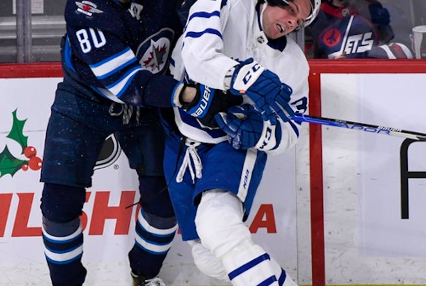 Winnipeg Jets forward Pierre-Luc Dubois (left) tangles with Maple Leafs sniper Auston Matthews on Dec. 5, 2021. Toronto will play host when the two teams meet again on Thursday night.