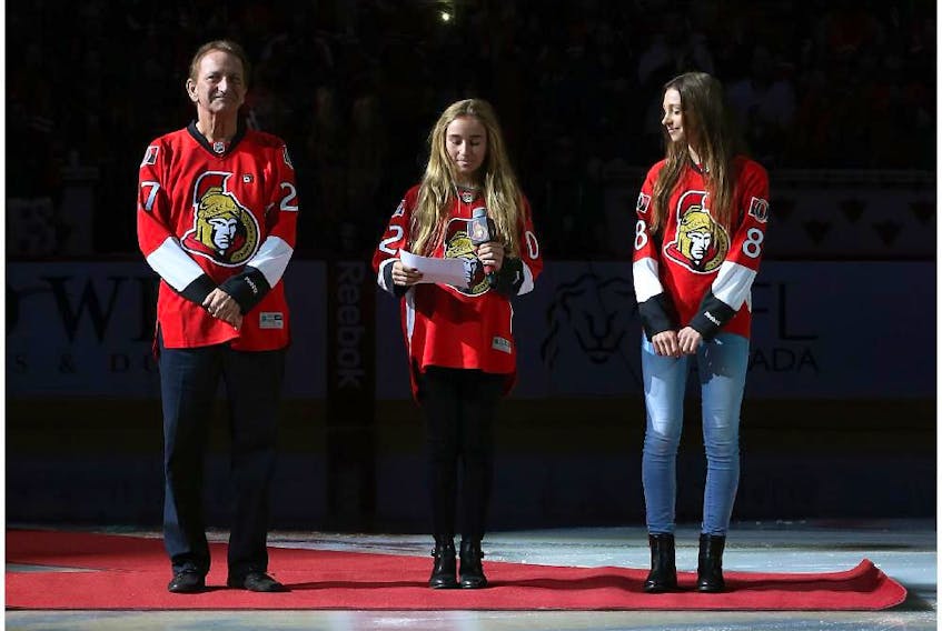 Ottawa Senators owner Eugene Melnyk stands at centre ice with his daughters Olivia and Anna before a Senators game in 2015.