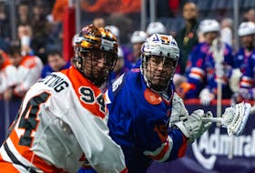 Shawn Evans of the Halifax Thunderbirds fires a shot past Buffalo Bandits defenceman Bryce Sweeting during their National Lacrosse League game Sunday night in Halifax. - NATIONAL LACROSSE LEAGUE