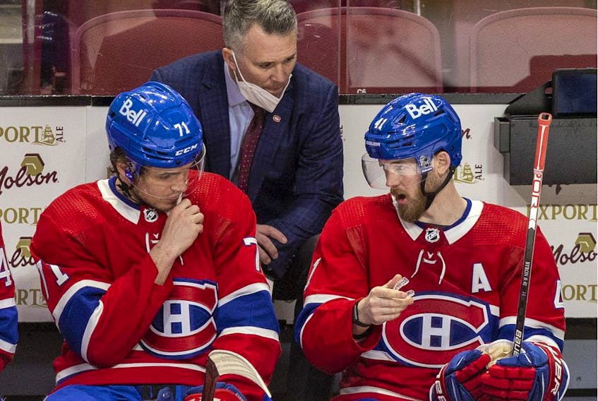 Canadiens interim head coach Martin St. Louis has a conversation with Jake Evans, left, and Paul Byron during a game last month at the Bell Centre.