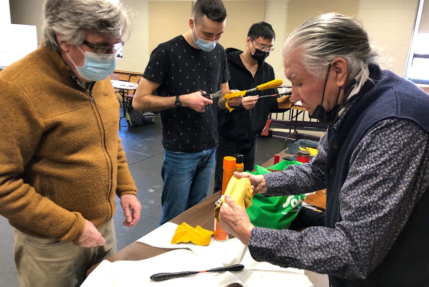 Elder Lawrence Wells of Membertou, right, shows CBU Public Health instructor Paul MacDougall, left, how to stretch the leather used on the traditional Mi'kmaw drumstick they are making, as students Ryan Power and Junie Yang work on their own creations during a workshop at the university. ARDELLE REYNOLDS/CAPE BRETON POST