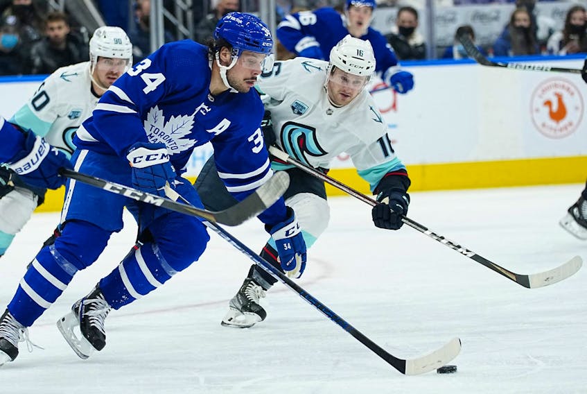 Toronto Maple Leafs forward Auston Matthews carries the puck past Seattle Kraken forward Jared McCann during the second period at Scotiabank Arena in Toronto, March 8, 2022. 