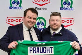 Swift Current Broncos general manager Chad Leslie, right, presents Devan Praught with a team jersey at a media conference earlier this week to introduce Praught as the ninth head coach in the history of the Western Hockey League franchise. Praught, from Summerside, began the season as an assistant coach and was promoted to interim head coach in mid-October. 