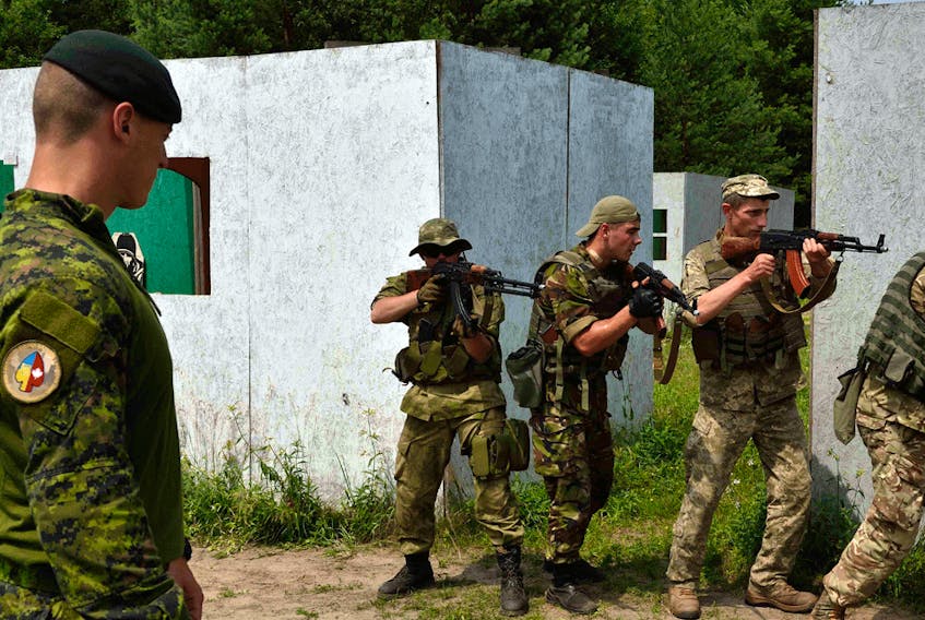 A Canadian instructor supervises the advance of Ukrainian soldiers during an exercise during Operation Unifier in Starychi, Ukraine in June 2016.