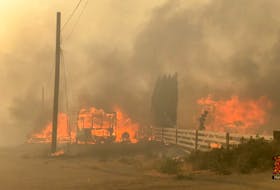 Flames rise from a burning building along a street during a wildfire in Lytton, B.C., on June 30, 2021 in this still image obtained from a 2 Rivers Remix Society video. The June heat wave in British Columbia has been called the “deadliest weather event in Canadian history”. 