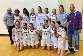 Members of the Citadel Phoenix pose with their Capital region division 1 girls’ basketball banner Friday night at Saint Mary’s University.