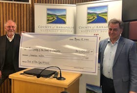 Annapolis County Warden Alan Parish, left, and CAO David Dick with a $17-million cheque after council approved a motion to sell its fibre optic network to Xplornet Communications Inc. on March 29.