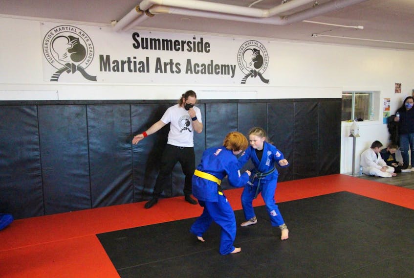 Itai Reeders keeps a close watch as Grayson Murnaghan and Teagan Wakelin participate in an in-house charity jiu-jitsu tournament at Summerside Martial Arts Academy. 