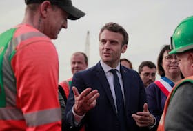French President and centrist presidential candidate for reelection Emmanuel Macron meets with workers as he visits a building site for Log's company in Denain, France on Monday April. Lewis Joly/Pool via REUTERS