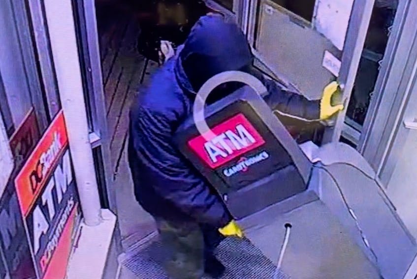 A thief wheels an ATM out of a Lawrencetown, N.S., laundromat on a dollie April 10.