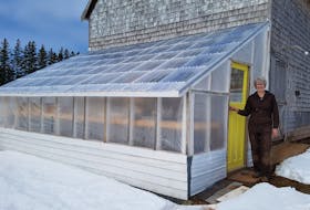 Heather MacLean of St. Peters Bay, P.E.I., stands in front of the greenhouse she built in late 2021.