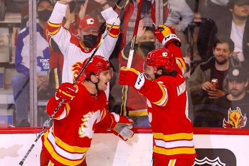Noah Hanifin (left) celebrates a goal against the Toronto Maple Leafs with fellow Calgary Flames defenceman Rasmus Andersson at Scotiabank Saddledome in Calgary on Feb. 10, 2022.