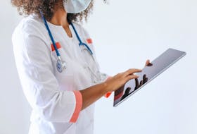 A nurse uses a tablet.
