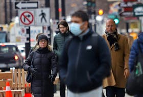 An array of masked and unmasked pedestrians are seen on Spring Garden Road in Halifax on Tuesday, March 22, 2022.