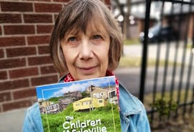 Author Christine Welldon with her book, The Children of Africville. Welldon spends half of her year in Lunenburg where she does most of her writing.