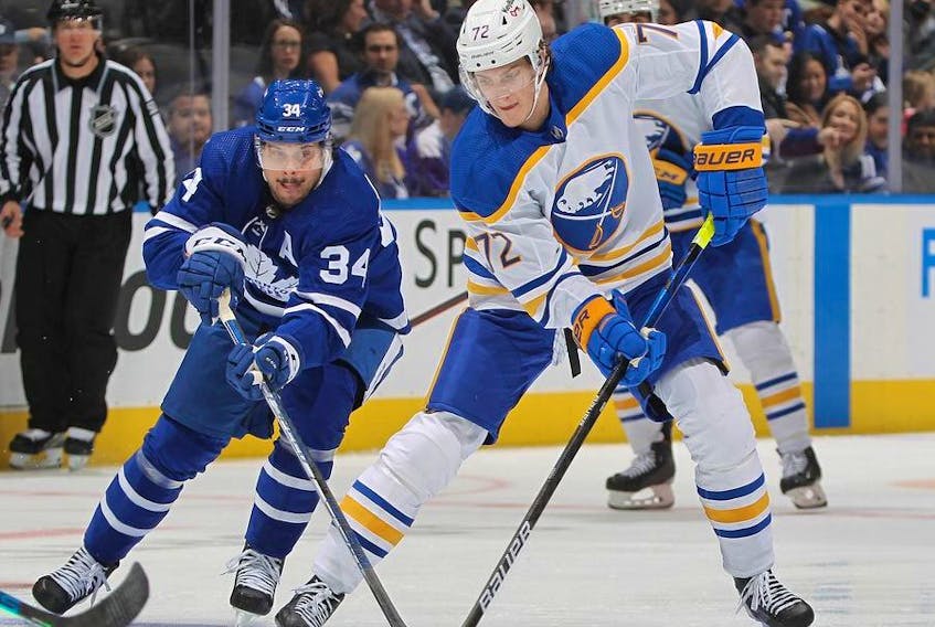 Tage Thompson of the Buffalo Sabres skates with the puck against Auston Matthews of the Toronto Maple Leafs during an NHL game at Scotiabank Arena on April 12, 2022 in Toronto, Ontario, Canada. 