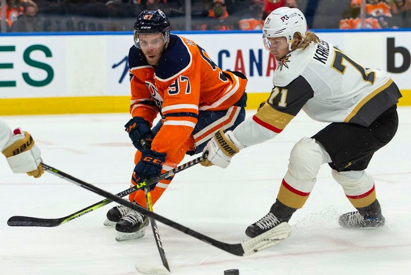 Edmonton Oilers' Connor McDavid (97) battles Las Vegas Golden Knights' Alex Pietrangelo (7) and William Karlsson (71) during first period NHL action at Rogers Place in Edmonton, on Tuesday, Feb. 8, 2022. 