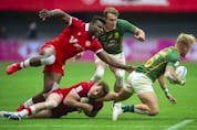 Canada's Matt Oworu and Phil Berna tackle South Africa's JC Pretorius in the HSBC World rugby Sevens Series at BC Place Stadium in Vancouver, BC Saturday, April 16, 2022. 
