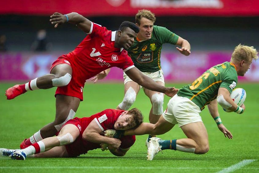 Canada's Matt Oworu and Phil Berna tackle South Africa's JC Pretorius in the HSBC World rugby Sevens Series at BC Place Stadium in Vancouver, BC Saturday, April 16, 2022. 
