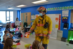 Captain Rich Johnson, with the Wolfville Fire Department, helped hand-deliver smoke detectors to schoolchildren at Wolfville Elementary School on April 13 while providing them with an important lesson in fire safety.