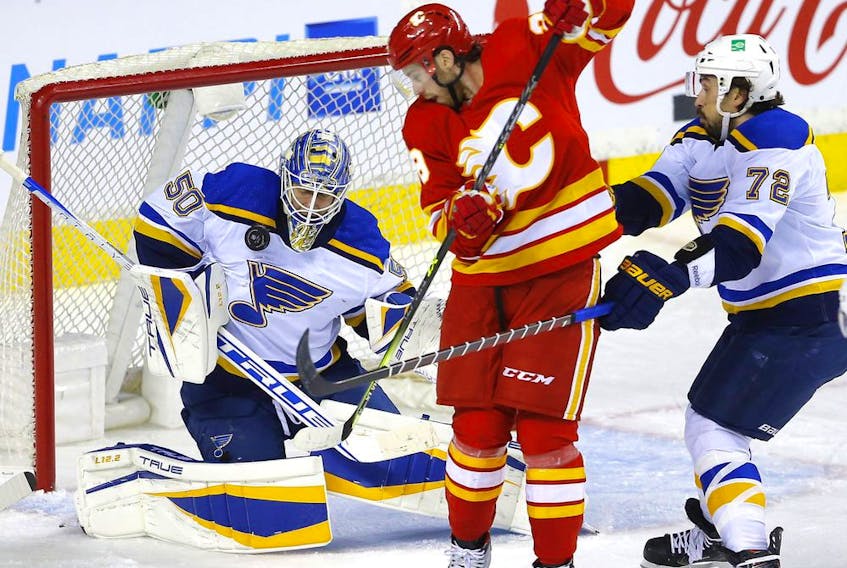 Calgary Flames forward Andrew Mangiapane is stopped by St. Louis Blues goalie Jordan Binnington at the Scotiabank Saddledome in Calgary on Jan. 24, 2022.