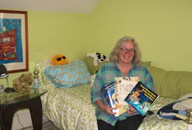 Joan Langevin Levack displays some of the children’s books she has for a Ukrainian family who has moved in with them after fleeing the war-torn country.
