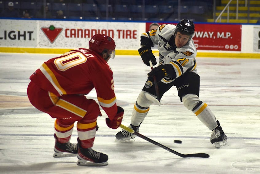 Romain Rodzinski of the Cape Breton Eagles, right, takes a point shot as Charles-Antoine Tremblay of the Baie-Comeau Drakkar attempts to get a stick on it during Quebec Major Junior Hockey League action at Centre 200, Thursday. Cape Breton won the game 5-2. JEREMY FRASER/CAPE BRETON POST.