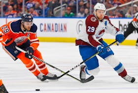 Edmonton Oilers forward Leon Draisaitl (29) and Colorado Avalanche forward Nathan MacKinnon (29) battle for a loose puck during the second period of Friday's NHL game at Rogers Place in Edmonton.