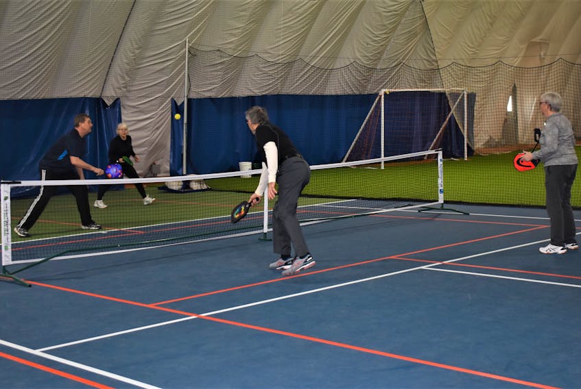 Area pickleball players playing mixed doubles recently at the Cougar Dome.