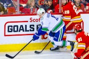  Apr 23, 2022; Calgary, Alberta, CAN; Vancouver Canucks centre Matthew Highmore (15) controls the puck against the Calgary Flames during the first period at Scotiabank Saddledome.
