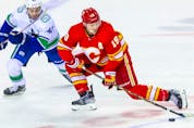  Apr 23, 2022; Calgary, Alberta, CAN; Calgary Flames left wing Matthew Tkachuk (19) and Vancouver Canucks defenceman Quinn Hughes (43) battle for the puck during the first period at Scotiabank Saddledome.