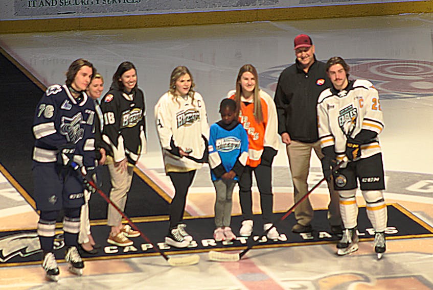 From left, Rimouski Oceanic's Frédéric Brunet, Lindsay MacIntosh, Christina Lamey, Blizzard U18 AA captain Brie Murrant, U9 player Dolapo Odumosu, Capers women's hockey captain Robyn LeBlanc, Rob Clemens of Dairy Queen Grand Lake Road and Eagles defenceman Sean Larochelle at a puck drop before the Oceanic-Eagles game Sunday at Centre 200. IAN NATHANSON/CAPE BRETON POST