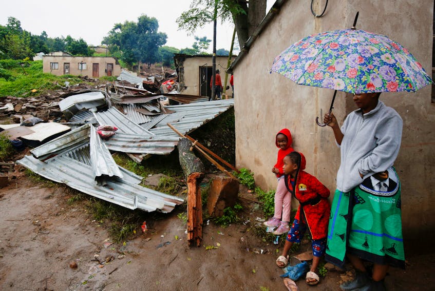 People stand near the remains of a building, which was destroyed during flooding leaving several people dead, at the KwaNdengezi Station, near Durban, South Africa, April 16, 2022. REUTERS/Rogan Ward  People stand near the remains of a building, which was destroyed during flooding that left several people dead, at the KwaNdengezi Station near Durban, South Africa on April 16. Southern Africa has been devastated by a series of major storm systems since January that have left millions homeless and many dead. REUTERS/Rogan Ward