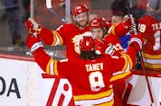  The Calgary Flames’ Elias Lindholm celebrates with goal against the Toronto Maples Leafs with Chris Tanev and Johnny Gaudreau at Scotiabank Saddledome in Calgary on Thursday, Feb. 10, 2022.