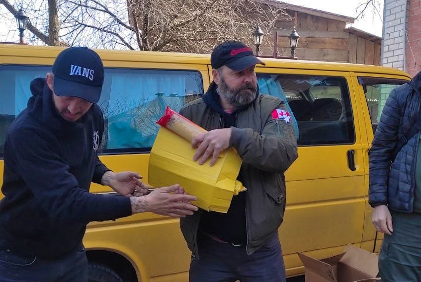 Lorne Goudie passes off a box of supplies during a delivery. CONTRIBUTED