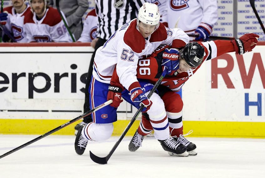Montreal Canadiens defenceman Justin Barron battles for the puck with New Jersey Devils centre Jack Hughes during the third on March 27, 2022, in Newark, N.J.