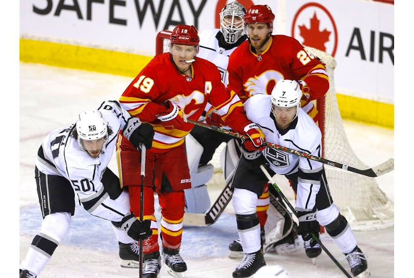 The Calgary Flames’ Matthew Tkachuk (19) and Elias Lindholm battle the Los Angeles Kings’ Sean Durzi (50) and Tobias Bjornfot in front of goaltender Cal Petersen at the Scotiabank Saddledome on Thursday, March 31, 2022. 