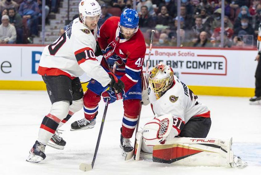 Ottawa Senators' goalie Anton Forsberg makes a save as teammate Alex Formenton ties up Montreal Canadiens' Paul Byron during third period of National Hockey League game in Montreal Tuesday, April 5, 2022.